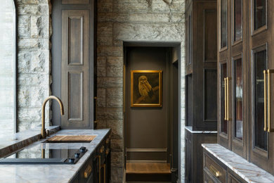 Large elegant galley limestone floor, gray floor and wallpaper ceiling kitchen pantry photo in Minneapolis with an undermount sink, recessed-panel cabinets, brown cabinets, marble countertops, paneled appliances, no island and gray countertops