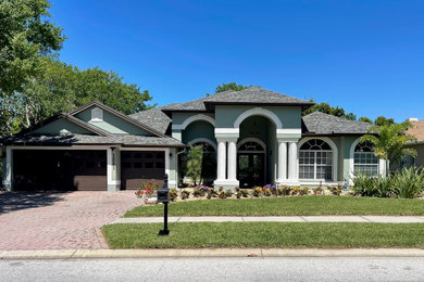 Arts and crafts green one-story house exterior photo in Tampa with a shingle roof and a gray roof