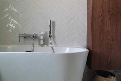 Immagine di una stanza da bagno design con ante lisce, vasca da incasso, piastrelle grigie, pavimento con piastrelle in ceramica, due lavabi e mobile bagno sospeso