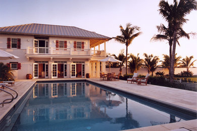 Inspiration for a mid-sized coastal white two-story mixed siding house exterior remodel in Miami with a hip roof and a metal roof