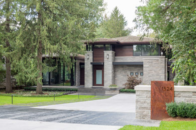 Photo of a large modern front yard driveway in Toronto with natural stone pavers.