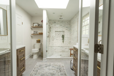 This is an example of a mid-sized transitional master bathroom in Chicago with shaker cabinets, medium wood cabinets, an alcove shower, gray tile, marble, porcelain floors, an undermount sink, engineered quartz benchtops, grey floor, a hinged shower door, white benchtops, a double vanity and a built-in vanity.