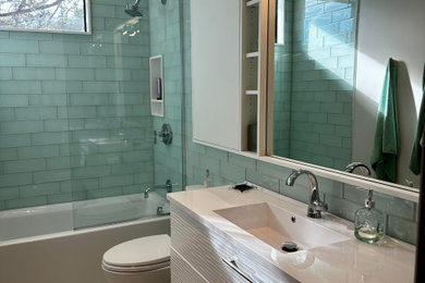Imagen de cuarto de baño único actual con baldosas y/o azulejos verdes, baldosas y/o azulejos de vidrio, suelo de baldosas de porcelana, suelo blanco, encimeras blancas y hornacina
