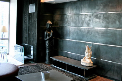 Example of a mid-sized asian enclosed medium tone wood floor and brown floor living room design in New York with black walls