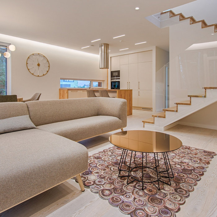 A modern living room with a staircase to the second floor, showcasing stylish budget luxury home design.