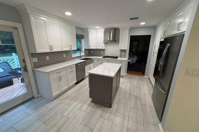 Large minimalist l-shaped porcelain tile and gray floor kitchen photo in Newark with a farmhouse sink, shaker cabinets, an island and white countertops