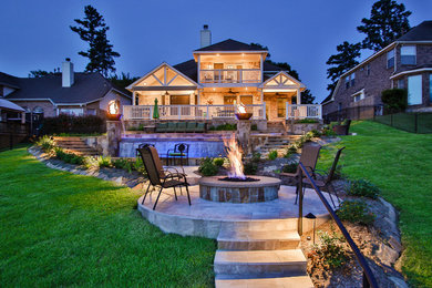 Patio - large tropical backyard tile patio idea in Houston with a fire pit and no cover