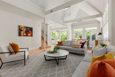 Photo of a small traditional living room in Melbourne with white walls, light hardwood floors, brown floor and exposed beam.