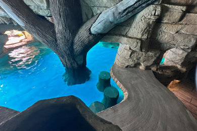 Example of a large tuscan backyard stamped concrete and custom-shaped natural pool landscaping design in Other