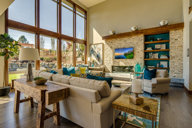 Example of a huge loft-style dark wood floor living room design in Portland with beige walls, a standard fireplace, a brick fireplace and a wall-mounted tv