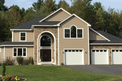 This is an example of a traditional two-storey beige exterior in Portland Maine with vinyl siding and a hip roof.