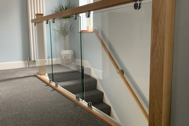 Clamped glass balustrade with oak handrail and newel posts