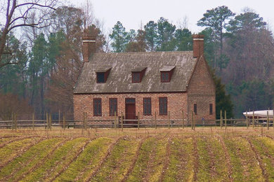 Example of a large classic red two-story brick gable roof design in New York