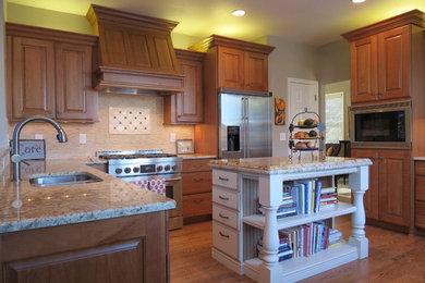 Mid-sized elegant u-shaped medium tone wood floor enclosed kitchen photo in Denver with a drop-in sink, raised-panel cabinets, medium tone wood cabinets, beige backsplash, stainless steel appliances and an island