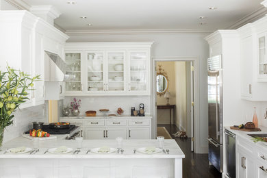 Kitchen - mid-sized dark wood floor and brown floor kitchen idea in New York with white cabinets, marble countertops, white backsplash and stainless steel appliances
