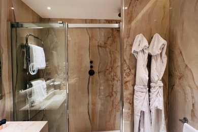 Mid-sized trendy master porcelain tile, brown floor and single-sink bathroom photo in Dallas with brown cabinets, an integrated sink, onyx countertops, brown countertops and a floating vanity