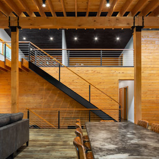 Идея дизайна: большая гостиная-столовая в стиле модернизм с оранжевыми стенами, паркетным полом среднего тона, двусторонним камином, фасадом камина из металла и серым полом