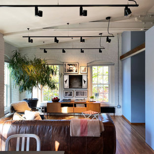 Mittelgroßes, Offenes Modernes Wohnzimmer mit braunem Holzboden, Wand-TV, freigelegten Dachbalken und Ziegelwänden in Boston