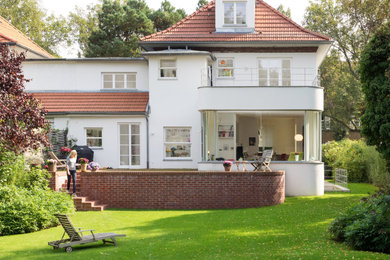 Dreistöckiges Klassisches Einfamilienhaus mit Putzfassade, weißer Fassadenfarbe, Mansardendach und Ziegeldach in Berlin