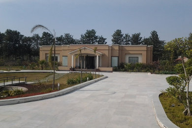 Mid-sized trendy beige one-story brick flat roof photo in Delhi