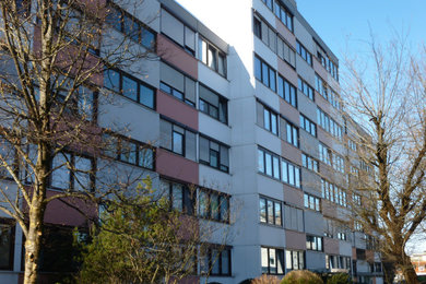 Kleines, Einstöckiges Modernes Wohnung mit Betonfassade, grauer Fassadenfarbe und Flachdach in Sonstige