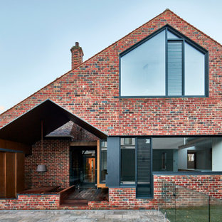 Inspiration for a mid-sized contemporary two-storey brick red house exterior in Melbourne with a gable roof.