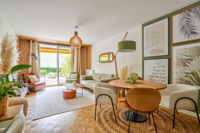 Cette photo montre un salon blanc et bois tendance de taille moyenne et ouvert avec un mur vert, parquet clair, aucune cheminée, un téléviseur indépendant, un sol marron et éclairage.