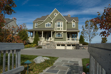 Large beach style green three-story house exterior photo in Other with a hip roof, a shingle roof and a brown roof