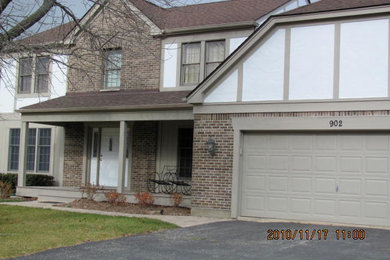 Example of a large classic beige two-story mixed siding exterior home design in Chicago with a clipped gable roof