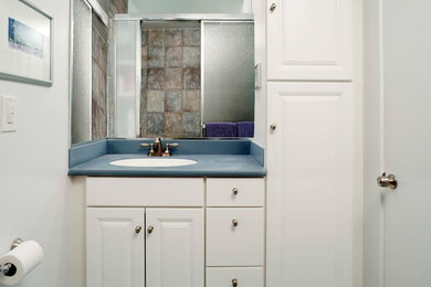 Alcove shower - small coastal 3/4 multicolored tile and porcelain tile porcelain tile alcove shower idea in Tampa with an undermount sink, raised-panel cabinets, white cabinets, solid surface countertops and white walls