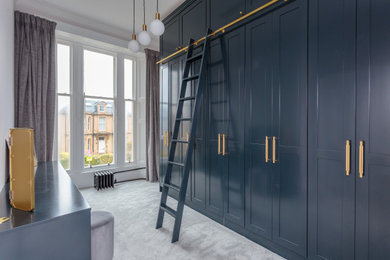 Ejemplo de vestidor unisex clásico de tamaño medio con armarios estilo shaker, puertas de armario de madera oscura, moqueta y suelo gris