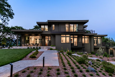 Diseño de fachada de casa verde contemporánea grande de dos plantas con revestimiento de aglomerado de cemento y tejado plano