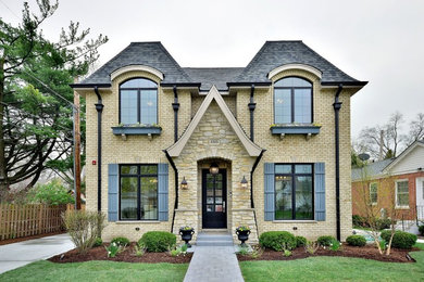 Inspiration for a timeless beige two-story brick house exterior remodel in Chicago with a hip roof and a shingle roof