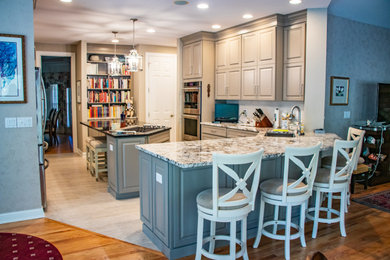 Inspiration for a mid-sized l-shaped vinyl floor and beige floor eat-in kitchen remodel in St Louis with gray cabinets, granite countertops, white backsplash, stainless steel appliances, an island and white countertops