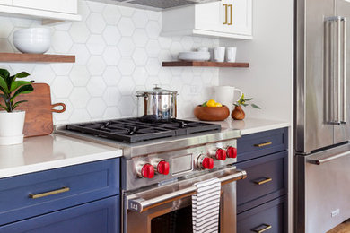 Eat-in kitchen - mid-sized transitional galley light wood floor and white floor eat-in kitchen idea in Chicago with an undermount sink, shaker cabinets, quartz countertops, white backsplash, stone tile backsplash, stainless steel appliances, an island, white countertops and blue cabinets