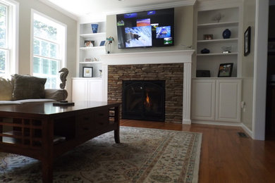 Photo of a traditional living room in Boston with a standard fireplace and a stone fireplace surround.