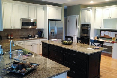 Eat-in kitchen - large u-shaped light wood floor eat-in kitchen idea in Philadelphia with an undermount sink, shaker cabinets, white cabinets, granite countertops, beige backsplash, ceramic backsplash, stainless steel appliances and an island