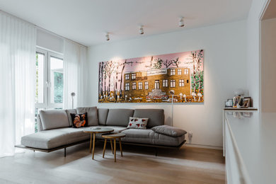 Mittelgroßes, Offenes Modernes Wohnzimmer mit weißer Wandfarbe, hellem Holzboden, Multimediawand und weißem Boden in Berlin