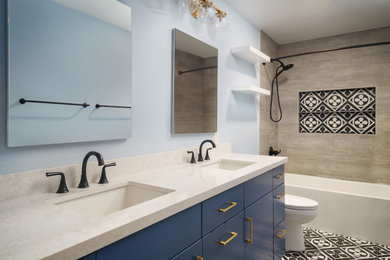 Mid-sized beach style kids' beige tile and ceramic tile cement tile floor, multicolored floor and double-sink alcove bathtub photo in Los Angeles with flat-panel cabinets, blue cabinets, a two-piece toilet, blue walls, an undermount sink, quartz countertops, white countertops and a built-in vanity