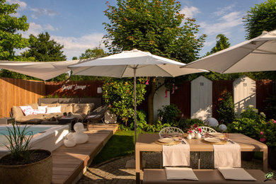 Geometrischer, Kleiner Mediterraner Garten im Sommer, neben dem Haus mit Blumenbeet, direkter Sonneneinstrahlung, Dielen und Holzzaun in Frankfurt am Main