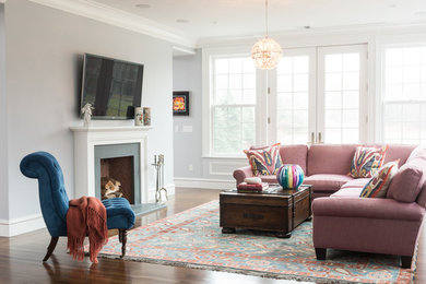 Inspiration for a timeless open concept dark wood floor and brown floor family room remodel in Boston with gray walls, a standard fireplace and a wall-mounted tv