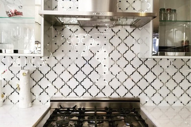 Eat-in kitchen - modern single-wall eat-in kitchen idea in New York with glass-front cabinets, white cabinets, white backsplash, mosaic tile backsplash and white appliances