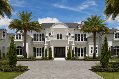 Mid-sized tuscan white two-story stucco house exterior photo in Miami with a hip roof and a shingle roof