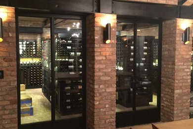 Design ideas for a large transitional wine cellar in New York with brick floors and display racks.