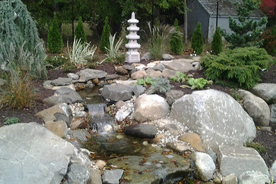 Photo of a small asian full sun backyard stone landscaping in Bridgeport.