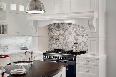 Inspiration for a large transitional u-shaped dark wood floor and black floor kitchen remodel in Boston with an undermount sink, shaker cabinets, white cabinets, marble countertops, gray backsplash, marble backsplash, black appliances and an island