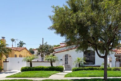 Inspiration for a mid-sized white one-story house exterior remodel in Los Angeles with a tile roof and a red roof