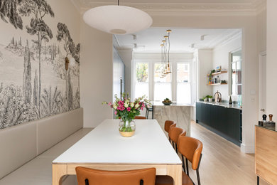 Mid-sized trendy light wood floor, beige floor and wallpaper breakfast nook photo in London with gray walls and no fireplace