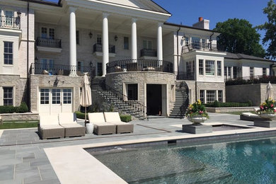 Large elegant three-story stone exterior home photo in Detroit