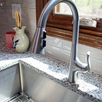 Gray Kitchen with Luna Pearl Granite Countertop and Taupe Tile Backsplash